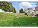 Spacious backyard with lush lawn, fire pit, and wooded backdrop, perfect for outdoor enjoyment at 7371 Vanguard Ct, Stanley, NC 28164