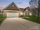 Charming brick home with attached garage, beautiful landscaping, and a wide driveway at 7371 Vanguard Ct, Stanley, NC 28164