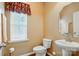 Well-lit half bathroom featuring a pedestal sink, modern toilet, and stylish window treatment at 7371 Vanguard Ct, Stanley, NC 28164