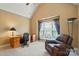 Comfortable home office with vaulted ceilings, a cozy chair, and ample natural light at 7371 Vanguard Ct, Stanley, NC 28164