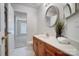 Bright bathroom with wooden cabinets, white countertop, and a decorative round mirror at 7836 Village Harbor Dr, Cornelius, NC 28031