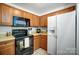 The kitchen features wood cabinetry, stone countertops, and black appliances at 7836 Village Harbor Dr, Cornelius, NC 28031