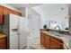 The bright kitchen features wood cabinetry, stone countertops, and a white refrigerator at 7836 Village Harbor Dr, Cornelius, NC 28031