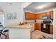 The kitchen features wood cabinets, stone countertops, and black appliances at 7836 Village Harbor Dr, Cornelius, NC 28031