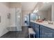 Bathroom featuring walk-in shower with bench, a double vanity, and blue cabinets at 8603 Bookwalter Ct, Charlotte, NC 28277