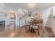 Hardwood floors flow in dining area next to staircase; a fireplace also can be seen at 8603 Bookwalter Ct, Charlotte, NC 28277