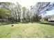 Expansive backyard with lush green grass, mature trees, and a storage shed providing a serene outdoor space at 9716 Sunway Dr, Mint Hill, NC 28227