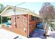 Side exterior view with brick facade, covered area, and a glimpse of the backyard at 9716 Sunway Dr, Mint Hill, NC 28227