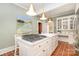 Spacious kitchen with a large island with gas range, terracotta floors, and stylish pendant lighting at 10 North Rd, Salisbury, NC 28144