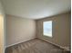 Neutral bedroom featuring carpet flooring, window, and electrical outlets at 10400 Brawley Ln # 8, Charlotte, NC 28215