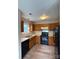 Well-equipped kitchen with wooden cabinets, black appliances, and laminate flooring, offering a functional cooking space at 10400 Brawley Ln # 8, Charlotte, NC 28215