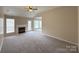 Spacious living room features a fireplace, neutral carpet, bright windows and a glass patio door at 10400 Brawley Ln # 8, Charlotte, NC 28215