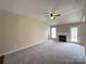 Bright living room with a cozy fireplace, plush carpeting, a ceiling fan and easy access to the outdoor area at 10400 Brawley Ln # 8, Charlotte, NC 28215