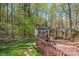 Wooden deck with built-in seating overlooks the landscaped backyard and storage shed at 125 Cove Creek Loop # 18, Mooresville, NC 28117