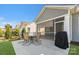 A patio with a table and chairs is just off the covered and screened-in porch at 13311 Union Square Dr, Huntersville, NC 28078