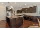 Open kitchen with island, granite countertops, dark cabinets, and stainless steel appliances at 13311 Union Square Dr, Huntersville, NC 28078