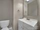 Neutral bathroom with white vanity, toilet, and classic fixtures at 13376 Calloway Glen Dr, Charlotte, NC 28273