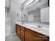 Bathroom featuring a double vanity, a large mirror, and a shower-tub combo at 13376 Calloway Glen Dr, Charlotte, NC 28273