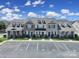 Exterior view of townhomes showing tidy landscaping, parking, and classic architectural details at 13376 Calloway Glen Dr, Charlotte, NC 28273