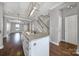 Modern kitchen island with stainless steel sink and breakfast bar seating opening to living area at 13376 Calloway Glen Dr, Charlotte, NC 28273