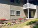 Charming condo with a white balcony, a small garden bed with vibrant flowers, and grassy area at 140 Lake Concord Ne Rd # D-1, Concord, NC 28025