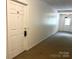 Well-maintained hallway with neutral carpet, an exit door, and a front door labeled 'D1' at 140 Lake Concord Ne Rd # D-1, Concord, NC 28025