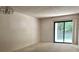 Bright living room with a sliding glass door, neutral carpet, and modern lighting fixture at 140 Lake Concord Ne Rd # D-1, Concord, NC 28025