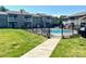 Community pool area featuring manicured lawn, black metal fence, and several lounging chairs at 140 Lake Concord Ne Rd # D-1, Concord, NC 28025