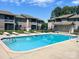 Inviting community pool area with chaise lounges, a fence, and well-maintained condo buildings at 140 Lake Concord Ne Rd # D-1, Concord, NC 28025