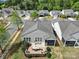 Aerial view of the property showcases the brick patio, screen porch, and lush landscaping in a neighborhood setting at 20202 Dovekie Ln, Indian Land, SC 29707