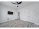 Bright bedroom with a ceiling fan, gray-toned wood flooring, and a wall-mounted television at 20202 Dovekie Ln, Indian Land, SC 29707