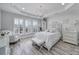 Serene main bedroom features a chandelier, tray ceiling, and large windows at 20202 Dovekie Ln, Indian Land, SC 29707