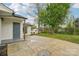 Backyard with a small patio area, a white shed, lush greenery and a beautiful shade tree at 2138 Syracuse Dr, Charlotte, NC 28216
