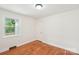 Empty bedroom with hardwood floors, white walls, and a window view at 2138 Syracuse Dr, Charlotte, NC 28216