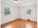 Bright, empty bedroom with hardwood floors and natural light from two windows at 2138 Syracuse Dr, Charlotte, NC 28216