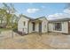 Exterior view of a white brick house with a fenced yard and a concrete patio at 2138 Syracuse Dr, Charlotte, NC 28216