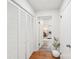 Hallway with wood flooring, closet, and doorway view of a bedroom with white paneled walls at 2138 Syracuse Dr, Charlotte, NC 28216