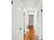 Hallway with hardwood flooring, white walls, and multiple doors leading to various rooms at 2138 Syracuse Dr, Charlotte, NC 28216