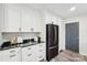 Spacious kitchen with white cabinets, black appliances, and sleek countertops at 2138 Syracuse Dr, Charlotte, NC 28216