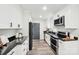 Modern kitchen featuring white cabinets, stainless steel appliances, and black granite countertops at 2138 Syracuse Dr, Charlotte, NC 28216