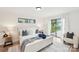 Bright main bedroom with white paneled walls, a slider to the backyard, and two side tables at 2138 Syracuse Dr, Charlotte, NC 28216