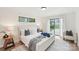 Bright main bedroom with white paneled walls, a slider to the backyard, and two side tables at 2138 Syracuse Dr, Charlotte, NC 28216