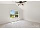 Bright bedroom with a ceiling fan and a large window with views of the surrounding greenery at 2628 S Main St, Kannapolis, NC 28027