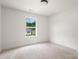 A bright bedroom featuring neutral carpeting, white walls and trim, and a window with view of the outdoors at 2628 S Main St, Kannapolis, NC 28027