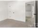 A bright bedroom with neutral carpeting and white trim is shown with an open doorway to the next room at 2628 S Main St, Kannapolis, NC 28027