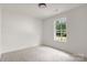 Bright bedroom featuring neutral carpeting, white walls and trim, and a window with view of the outdoors at 2628 S Main St, Kannapolis, NC 28027