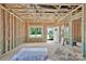 Unfinished living room with exposed framing, a window overlooking the yard, and an open doorway at 2628 S Main St, Kannapolis, NC 28027