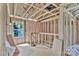Unfinished room featuring exposed framing, pink insulation, and a window overlooking the yard at 2628 S Main St, Kannapolis, NC 28027