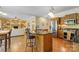 Open-concept kitchen with granite island, stainless appliances, and adjacent living space with fireplace and built-ins at 273 S Downs Way, Fort Mill, SC 29708