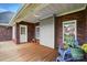 Cozy back porch with red brick, white trim, and wood flooring for outdoor enjoyment at 3011 Patrick Place Cir, Clover, SC 29710